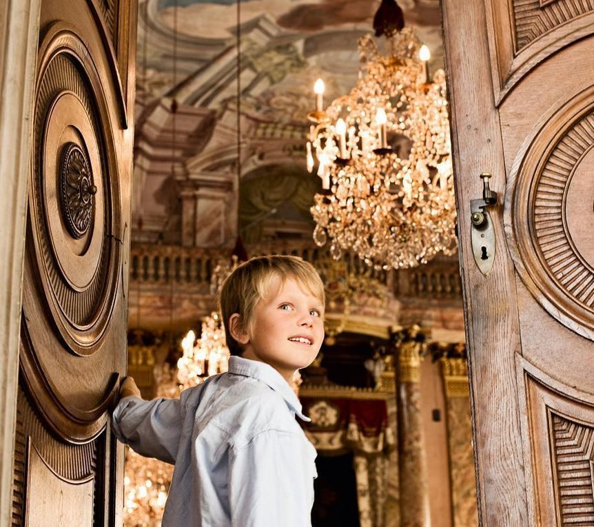 Ein Junge öffnet eine Tür im Residenzschloss Ludwigsburg
